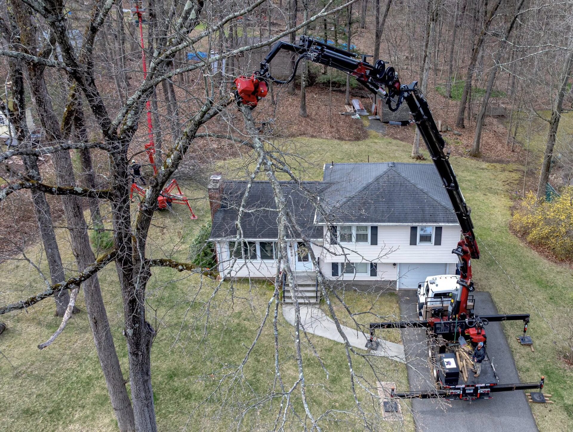 Aerial view of USA Tree Experts using a crane and spider lift to perform tree trimming at a residential home in Wethersfield, CT